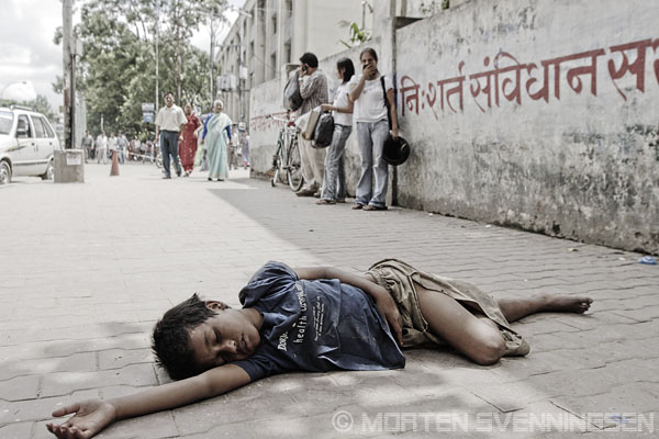 Image Credit: http://carmensandiegotravel.blogspot.com - 11-year old boy who has been living on the streets since he was 9. Shoppers in the background. Kathmandu, Nepal, 2006 -